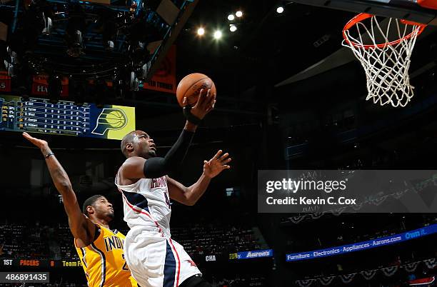 Paul Millsap of the Atlanta Hawks drives past Paul George of the Indiana Pacers n Game Four of the Eastern Conference Quarterfinals during the 2014...