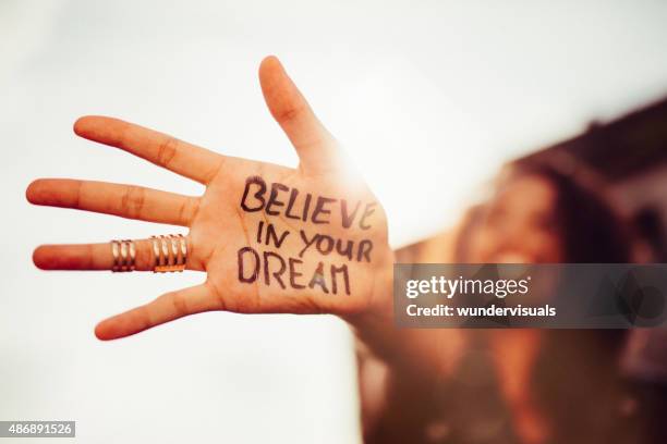 girl's hand with "believe in your dreams" written on it - ethereal stock pictures, royalty-free photos & images