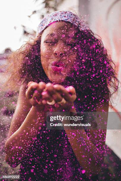 bright pink glitter being blown by a teenage girl - lila stockfoto's en -beelden