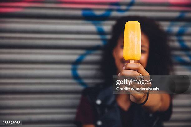 girl holding an ice lolly in front of her face - ice lolly stock pictures, royalty-free photos & images