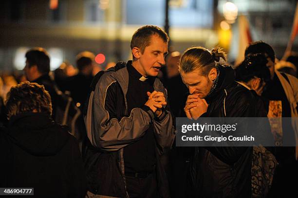 Pilgrim confess to a priest during a Mass celebration in front of the Church of Santa Agense in Agona, at Piazza Navona on April 26, 2014 in Rome,...