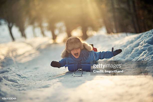 kleine junge spaß auf dem schlitten im winter worest. - kids playing snow stock-fotos und bilder