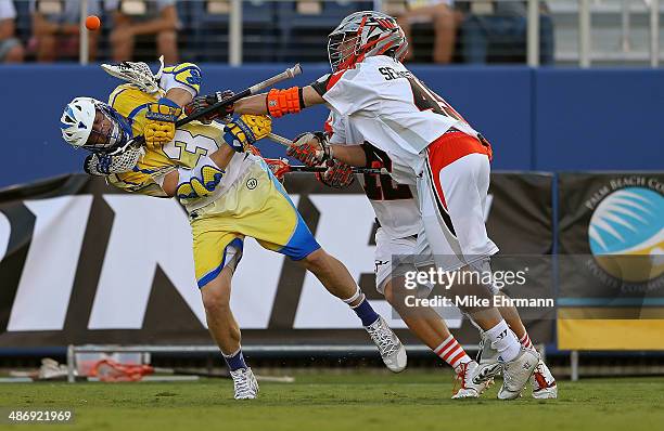 Brett Garber of the Florida Launch loses the ball guarded by Domenic Sebastiani of the Denver Outlaws during a game at FAU Stadium on April 26, 2014...