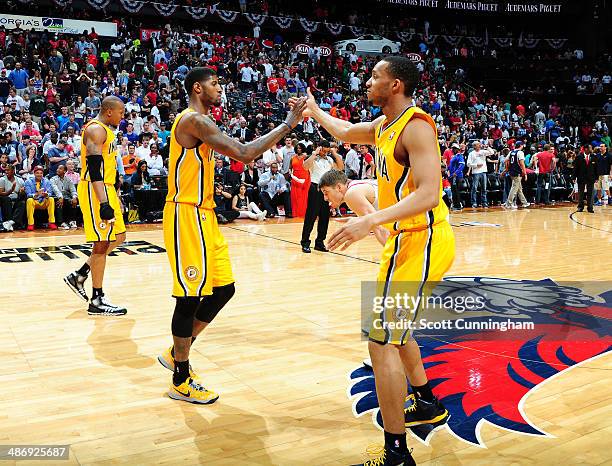 Paul George and Evan Turner of the Indiana Pacers slap hands during a game against the Atlanta Hawks during Game Four of the Eastern Conference...