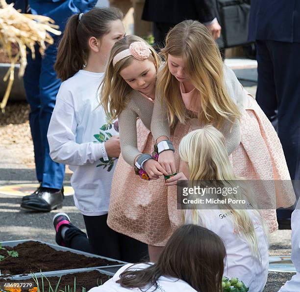 Princess Ariane of The Netherlands and Princess Alexia of The Netherlands learn about planing seeds during King's Day celebrations on April 26, 2014...