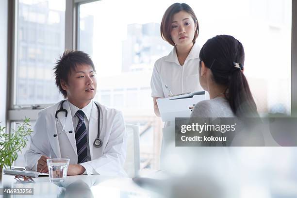 doctor listening to his patient talking in bright surgery - puke japan stock pictures, royalty-free photos & images