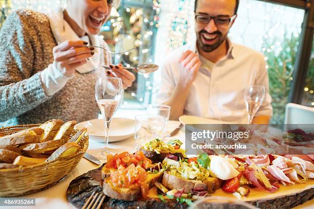 coppia avendo una cena in un ristorante di natale - coppie cibo food bistrot foto e immagini stock