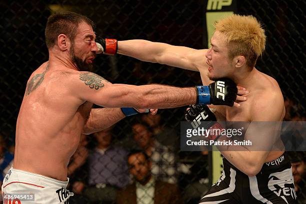 Takanori Gomi punches Isaac Vallie-Flagg in their lightweight bout during the UFC 172 event at the Baltimore Arena on April 26, 2014 in Baltimore,...