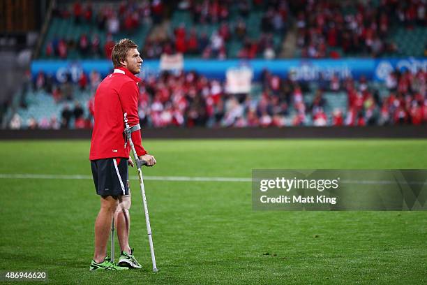 Kieren Jack of the Swans waits on the field on crutches at fulltime after sustaining an injury during the round 23 AFL match between the Sydney Swans...