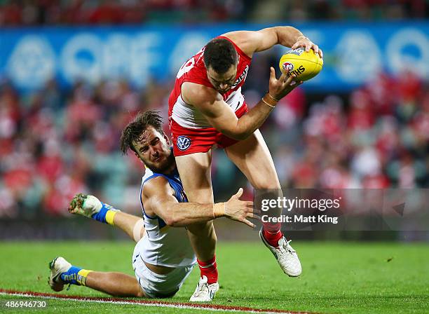 Heath Grundy of the Swans is tackled by Charlie Dixon of the Suns during the round 23 AFL match between the Sydney Swans and the Gold Coast Suns at...