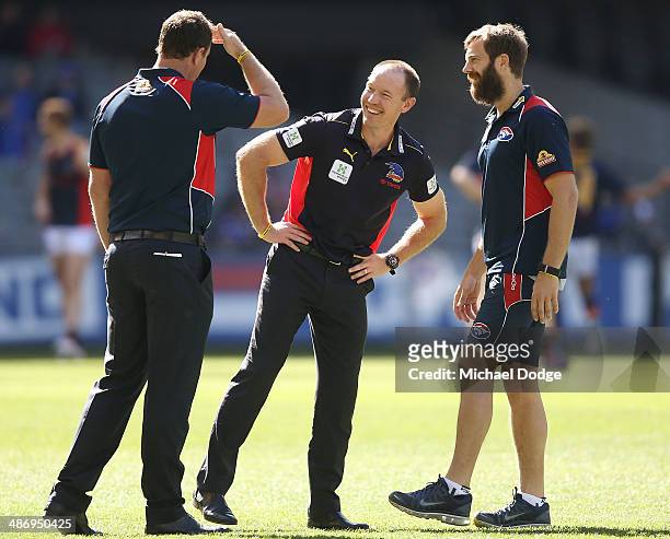 Crows coach Brenton Sanderson reacts with Ben Graham and Joel Corey of the Bulldogs during the round six AFL match between the Western Bulldogs and...