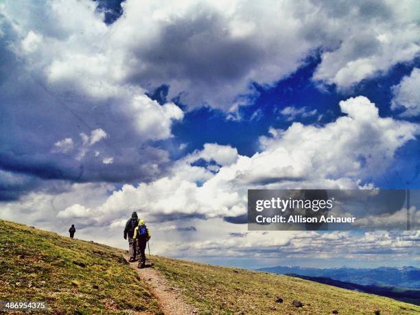 Hikers under an incredible sky, headed to the summit of Mount Washburn