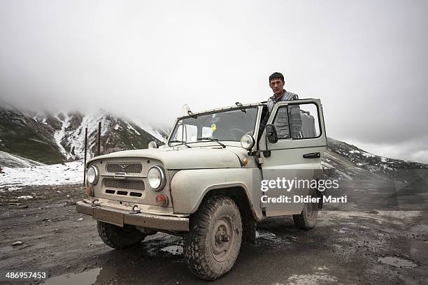 Driver with his UAZ in the mountains along the Pamir Highway in Kyrgyzstan