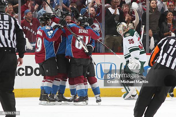 Nick Holden of the Colorado Avalanche is congratulated by teammates Nathan MacKinnon and Andre Benoit after his second period goal as goaltender...
