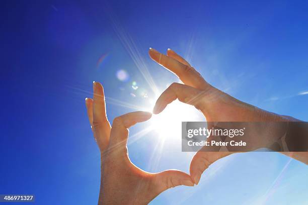hand in shape of heart held up to sun - hands sun stock pictures, royalty-free photos & images