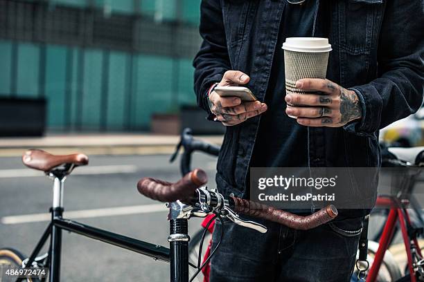 commuter parking his bicycle outside the office - hipster candid stockfoto's en -beelden