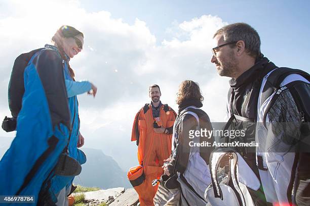 group of wingsuit jumpersget ready to launch - base jumping stock pictures, royalty-free photos & images
