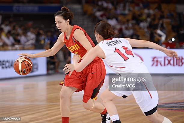 Di Wu of China handles the ball while Sanae Motokawa of Japan competes in finals match between Japan and China during the 2015 FIBA Asia Championship...