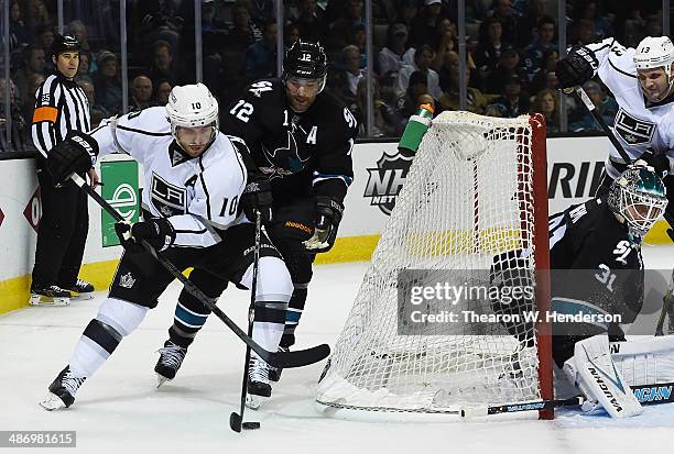 Mike Richards of the Los Angeles King attacks the goal from behind the net keeping the puck away from Patrick Marleau of the San Jose Sharks in the...