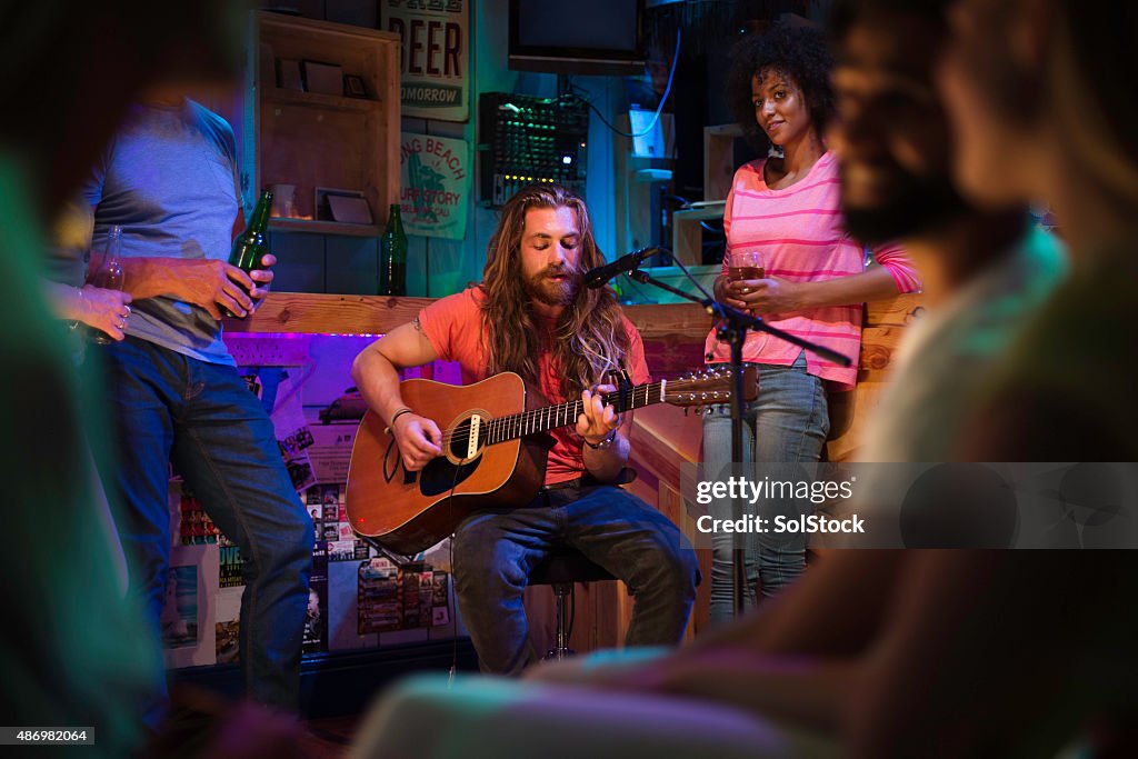 Cantante/compositor jugando en el Bar Local
