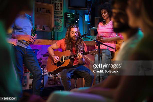 singer/songwriter playing in local bar - musician stock pictures, royalty-free photos & images