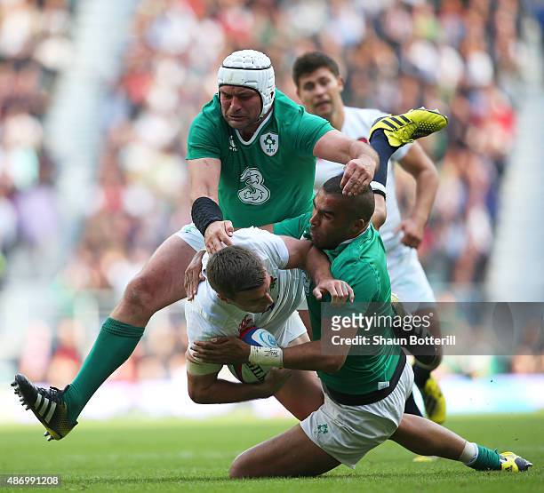 George Ford of England is hauled down by Simon Zebo of Ireland and Rory Best of Ireland during the QBE International match between England and...