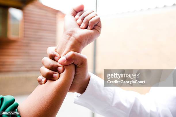 school boy grabs girls arm - violence stock pictures, royalty-free photos & images