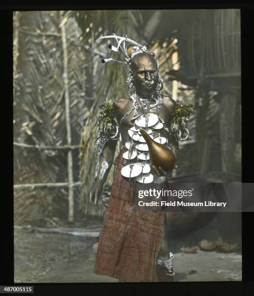 Man adorned for dance, wearing dancing regalia, arm bands, shell ornament necklace and a Tapa bark cloth skirt, Papua New Guinea, August 1, 1910.
