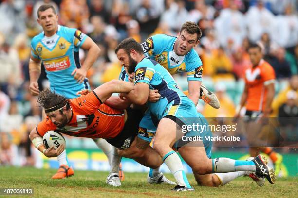 Aaron Woods of the Tigers is tackled during the round 8 NRL match between the Wests Tigers and the Gold Coast Titans at Leichhardt Oval on April 27,...