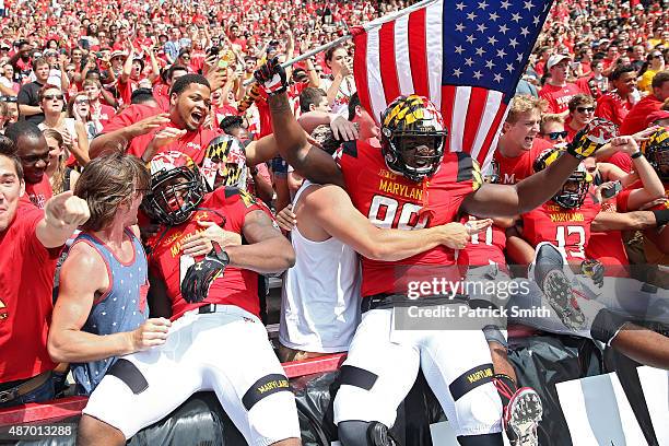 Defensive lineman Quinton Jefferson of the Maryland Terrapins and teammates jump into the crowd before playing the Richmond Spiders at Byrd Stadium...