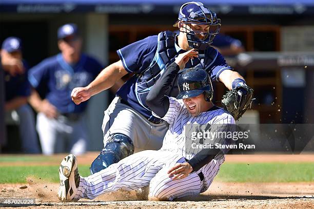 John Ryan Murphy of the New York Yankees slides in safely to score a run in the fifth inning past the tag of Luke Maile of the Tampa Bay Rays at...