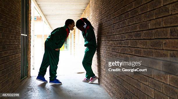 school boy shouting at school girl - school building silhouette stock pictures, royalty-free photos & images