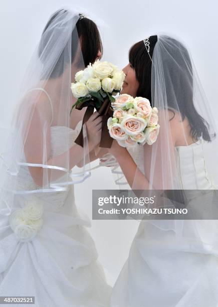 Lesbian couple kisses as they pose for photos taken by a wedding photo service company in Tokyo before participating in the "Tokyo Rainbow Pride"...