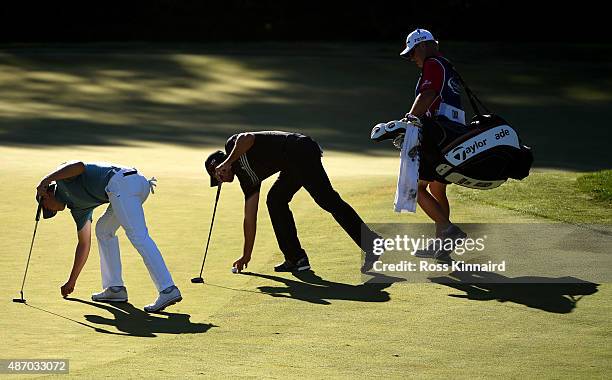 Jordan Spieth and Jason Day of Australia place their markers on the 12th green during round two of the Deutsche Bank Championship at TPC Boston on...