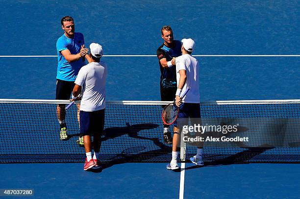 Sam Groth and Lleyton Hewitt of Australia shake hands with Colin Fleming of Great Britain and Treat Huey of the Philippines after their Men's Doubles...
