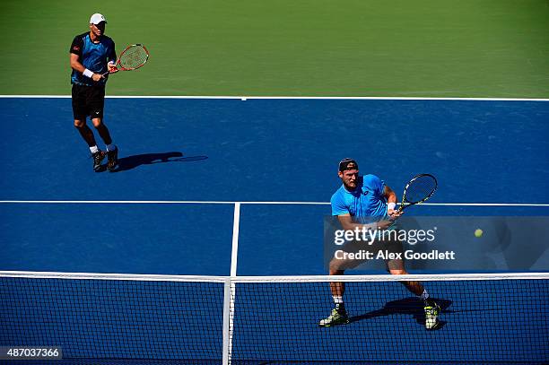 Sam Groth and Lleyton Hewitt of Australia return a shot against Colin Fleming of Great Britain and Treat Huey of the Philippines during their Men's...