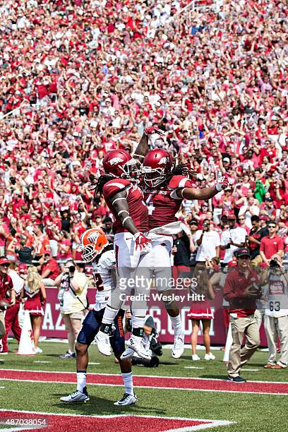 Alex Collins and Keon Harcher of the Arkansas Razorbacks celebrate after a touchdown against the UTEP Miners at Donald W. Reynolds Razorback Stadium...