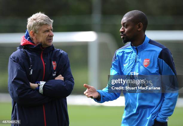 Arsenal manager Arsene Wenger talks with Abou Diaby during a training session at London Colney on April 27, 2014 in St Albans, England.