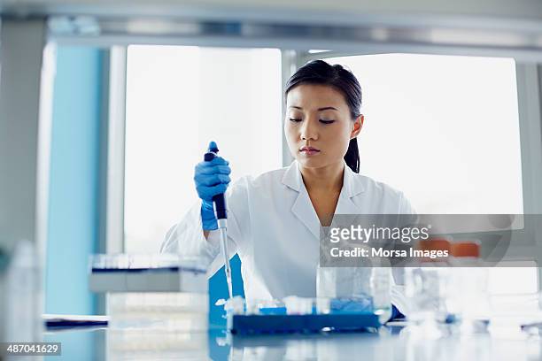 scientist using pipette in research laboratory - medical research foto e immagini stock