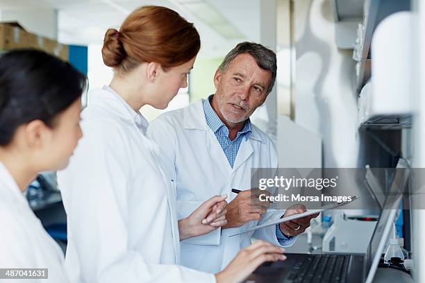 research team discussing results - laboratory technician stock-fotos und bilder