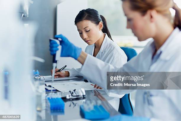 scientists working in modern laboratory - surgical glove stock pictures, royalty-free photos & images
