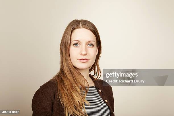 portrait of young woman looking to camera - fond beige photos et images de collection