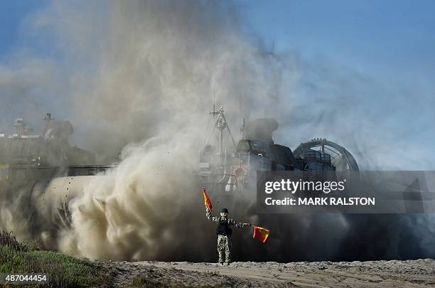 Signalman directs a US Marines Landing Craft Air Cushion hovercraft during an amphibious landing operation with the Japan Maritime Self-Defense Force...