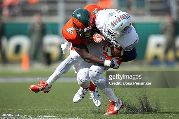 Ker-Sean Wilson of the Savannah State Tigers makes a pass reception and is tackled by Kevin Pierre-Louis of the Colorado State Rams at Sonny Lubick...