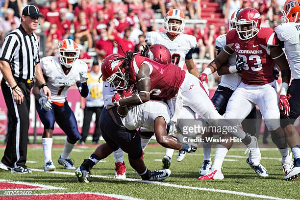 Alex Collins of the Arkansas Razorbacks is hit at the goal line but powers in for a touchdown against the UTEP Miners at Razorback Stadium on...
