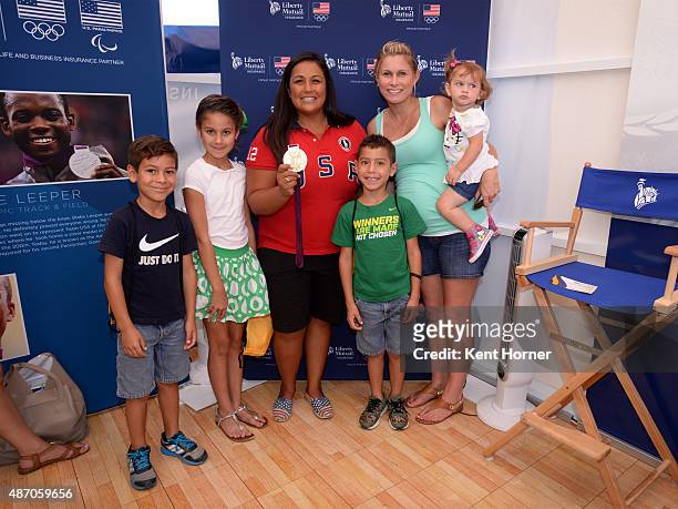 Time Olympic Water Polo player Brenda Villa shows off her London Olympic Gold medal while posing with fans inside the Liberty Mutual tent at the USOC...