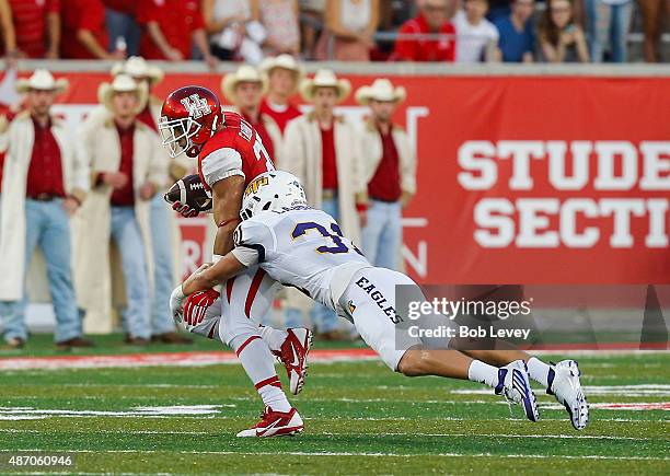 Kenneth Farrow of the Houston Cougars is tackled from behind by Jimmy Laughlin of the Tennessee Tech Golden Eagles during the game at TDECU Stadium...