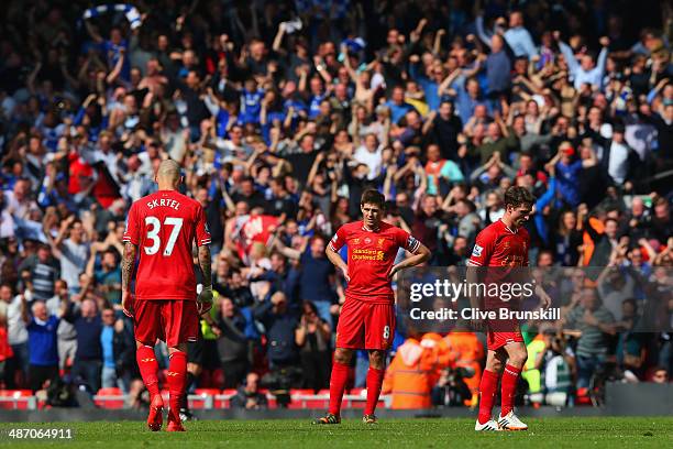 Dejected Martin Skrtel, Steven Gerrard and Joe Allen of Liverpool look on as the Chelsea fans celebrate after Willian of Chelsea scored their second...