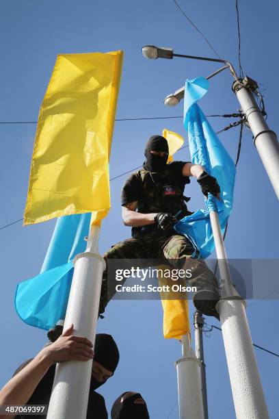 Pro-Russian activist rips down blue and yellow banners which were displayed outside a business along the route of a protest march on April 27, 2014...