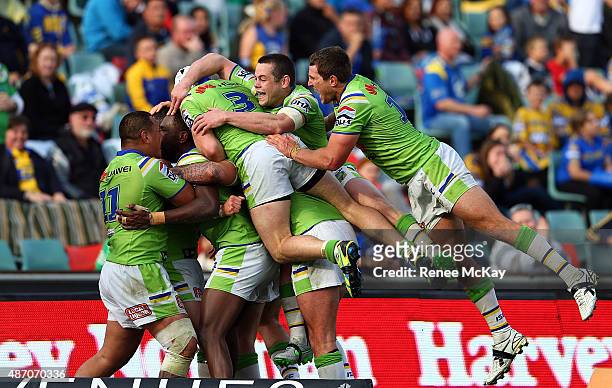 Josh Hodgson of the Raiders celebrates his try with team mates during the round 26 NRL match between the Parramatta Eels and the Canberra Raiders at...